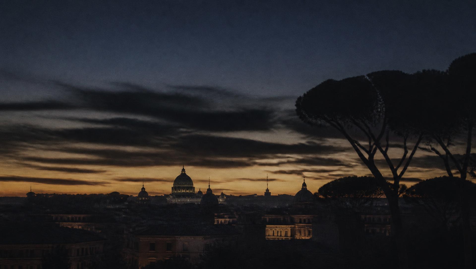 Rome skyline silhouetted against a warm dusk sky